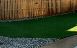 artificial grass in a backyard with a fence