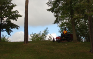 man on a lawn mower taking care of a property